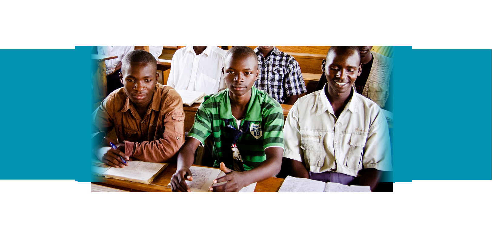 Three boys sitting at a desk. YouthPower Action Mozambique Three boys sitting at a desk. YouthPower Action Mozambique